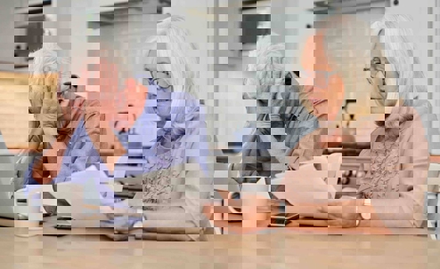 A stressed elderly couple reviewing financial papers during a divorce