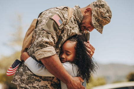 service member hugging daughter
