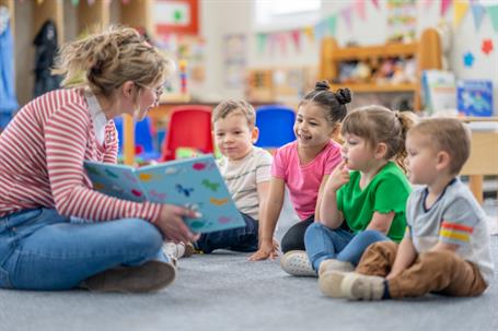 Women reading a book to children