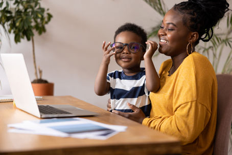 mother and son sitting at a desk with a laptop